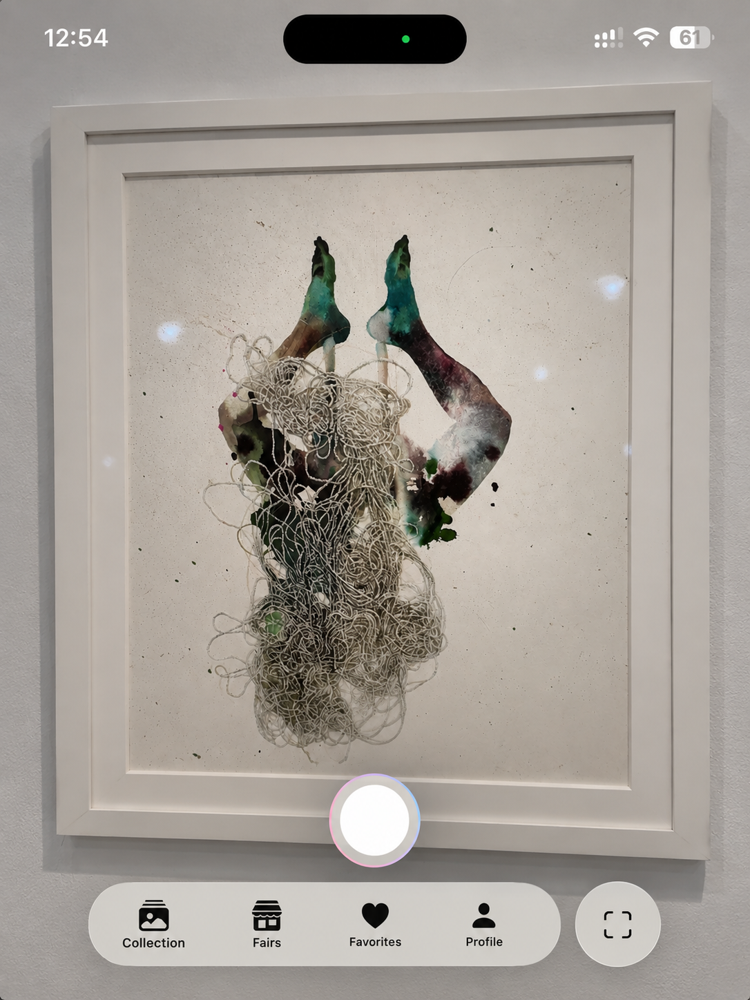 Phone screen showing the app camera aimed at a framed mixed-media work on a gallery wall, with the shutter and the Collection, Fairs, Favorites and Profile tabs below